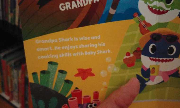 My son’s book, chronicling the adventures of a feisty young shark and his extended family, featuring white text on a light yellow background