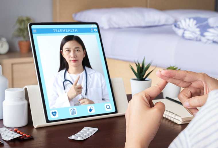 Doctor and patient using sign language over a video call on a tablet device