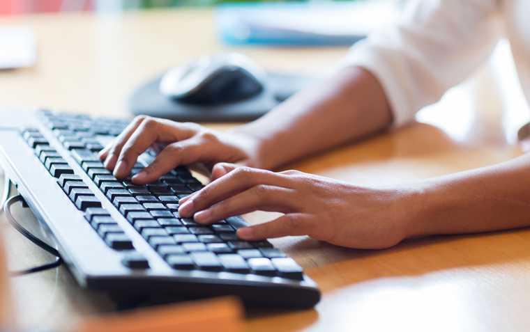 hands poised at the keys of a mechanical style keyboard