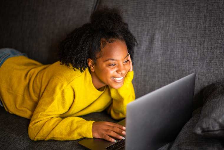 Young girl on laptop smiling